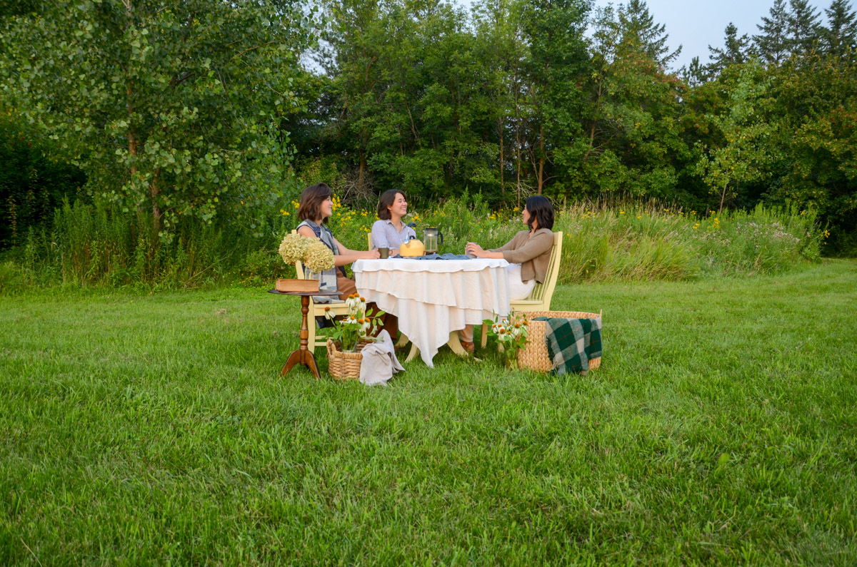 3 women at a table in a field