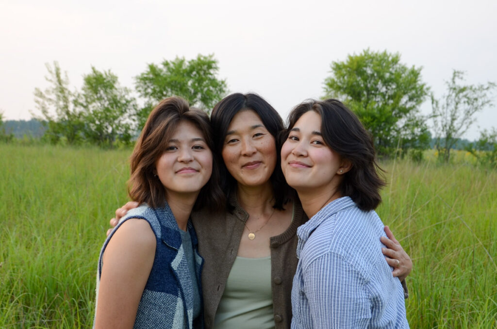 3 women hugging in a field